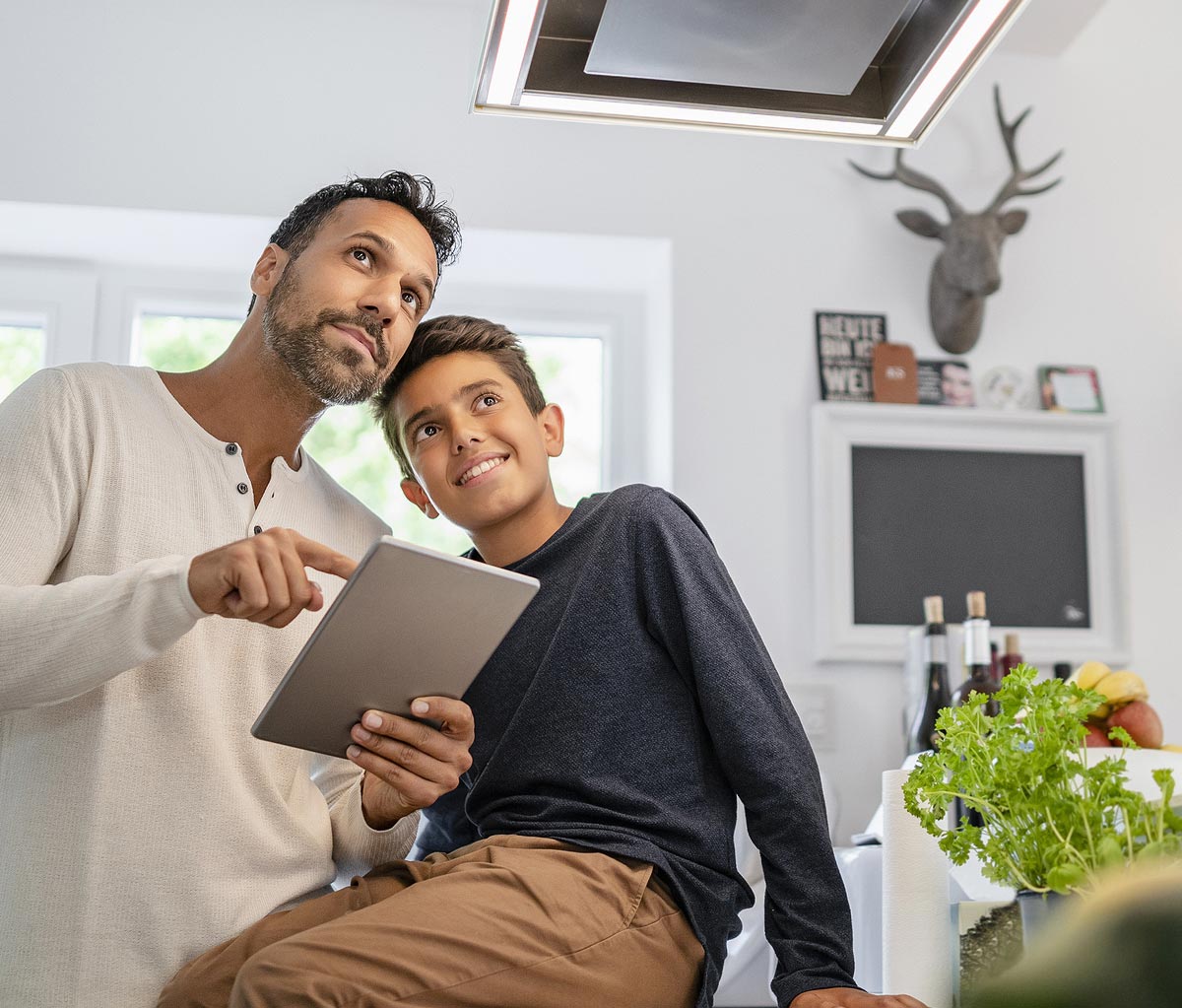 Father and son sharing a moment by the Vestaboard