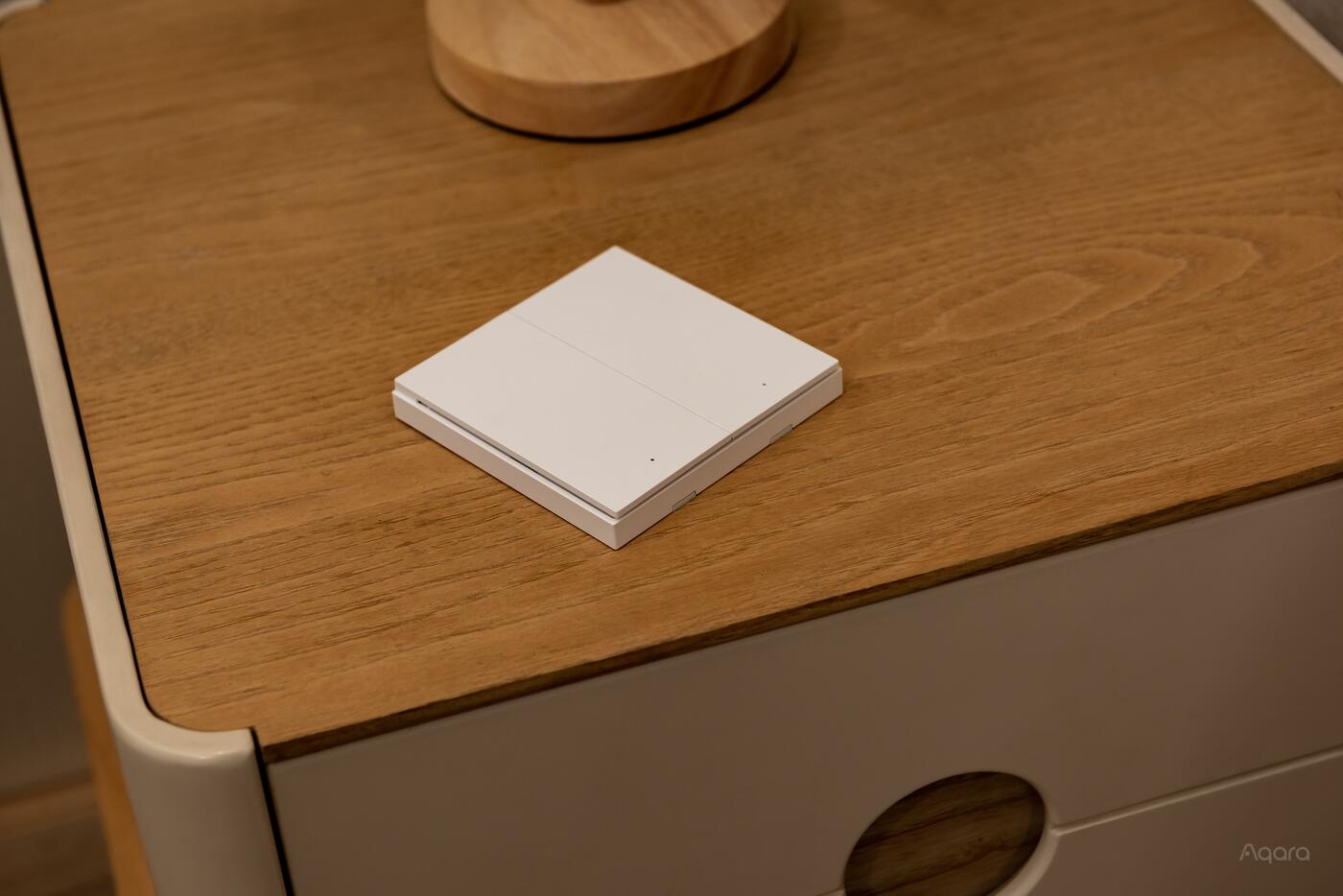 Aqara H1 wireless wall switch on a bedside table