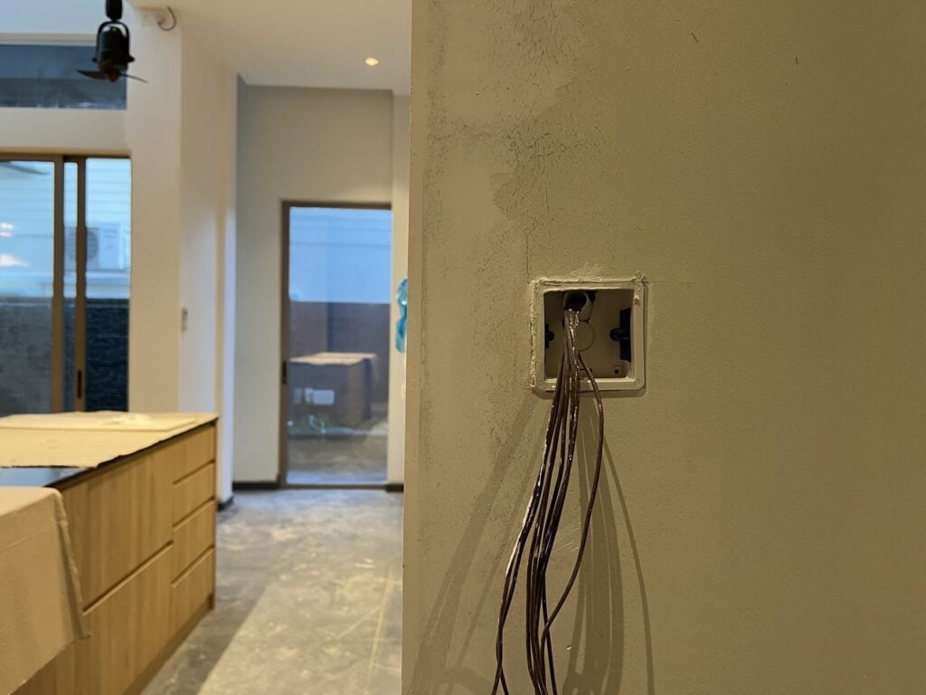 An open wall box with switch wiring in a home under renovation
